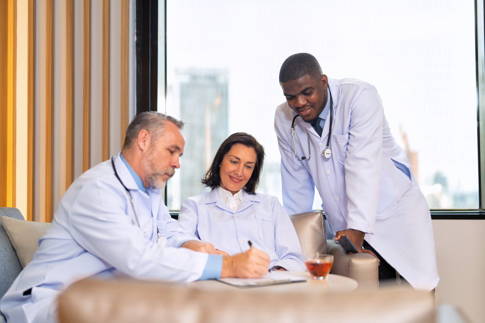 Healthcare doctors sitting on sofa in pantry room at modern hospital relax briefing patient case