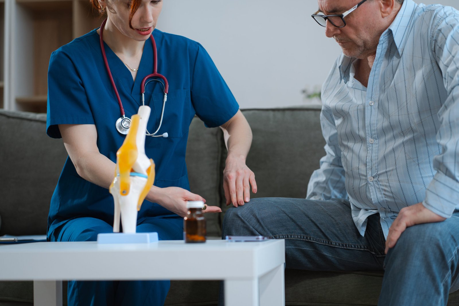 Knee model showing the process of osteoarthritis and knee arthroplasty, doctors explaining symptoms and treatment to patients.