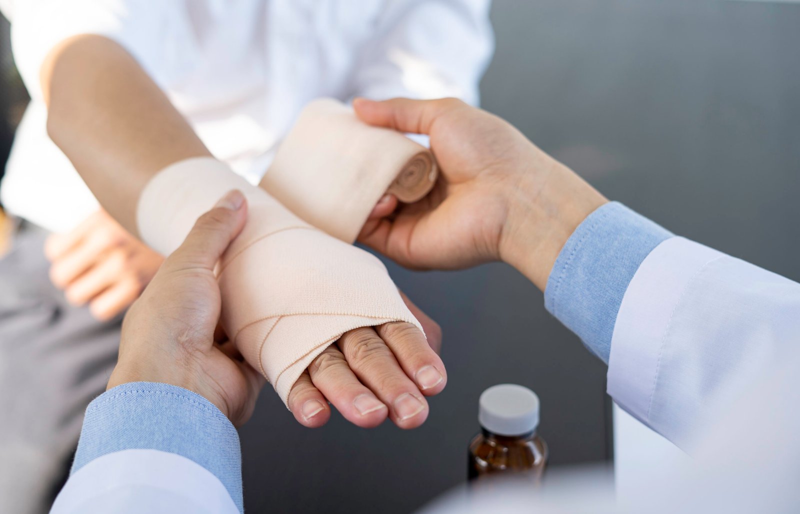 A doctor wrapped around the wrist for first aid Close-up with a particular emphasis on the application of bandages on the patient's hands, first aid concepts and wrist injury treatment.