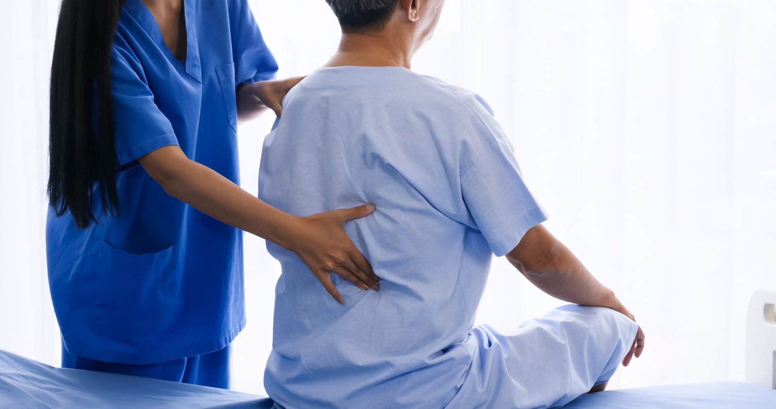 Female physical therapist doing physical therapy for adult patient at hospital room.