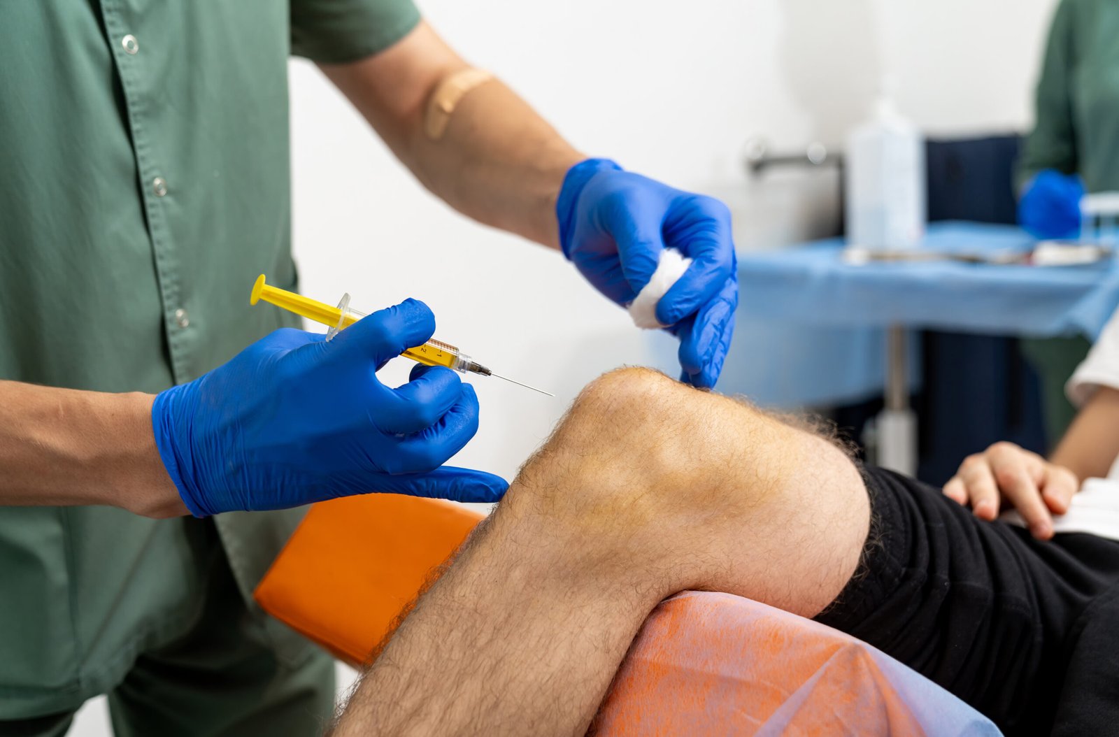 Knee medical injection. Doctor hand holding syringe for injection to knee.