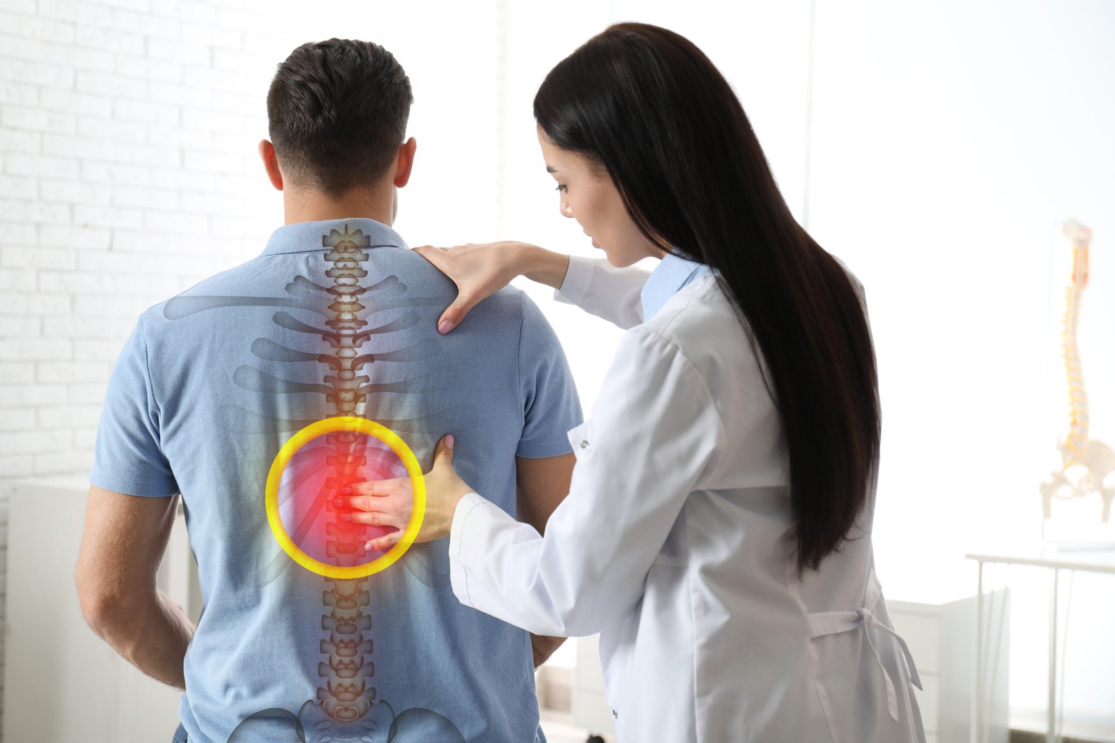 Professional orthopedist examining man in medical office. Spinal pain
