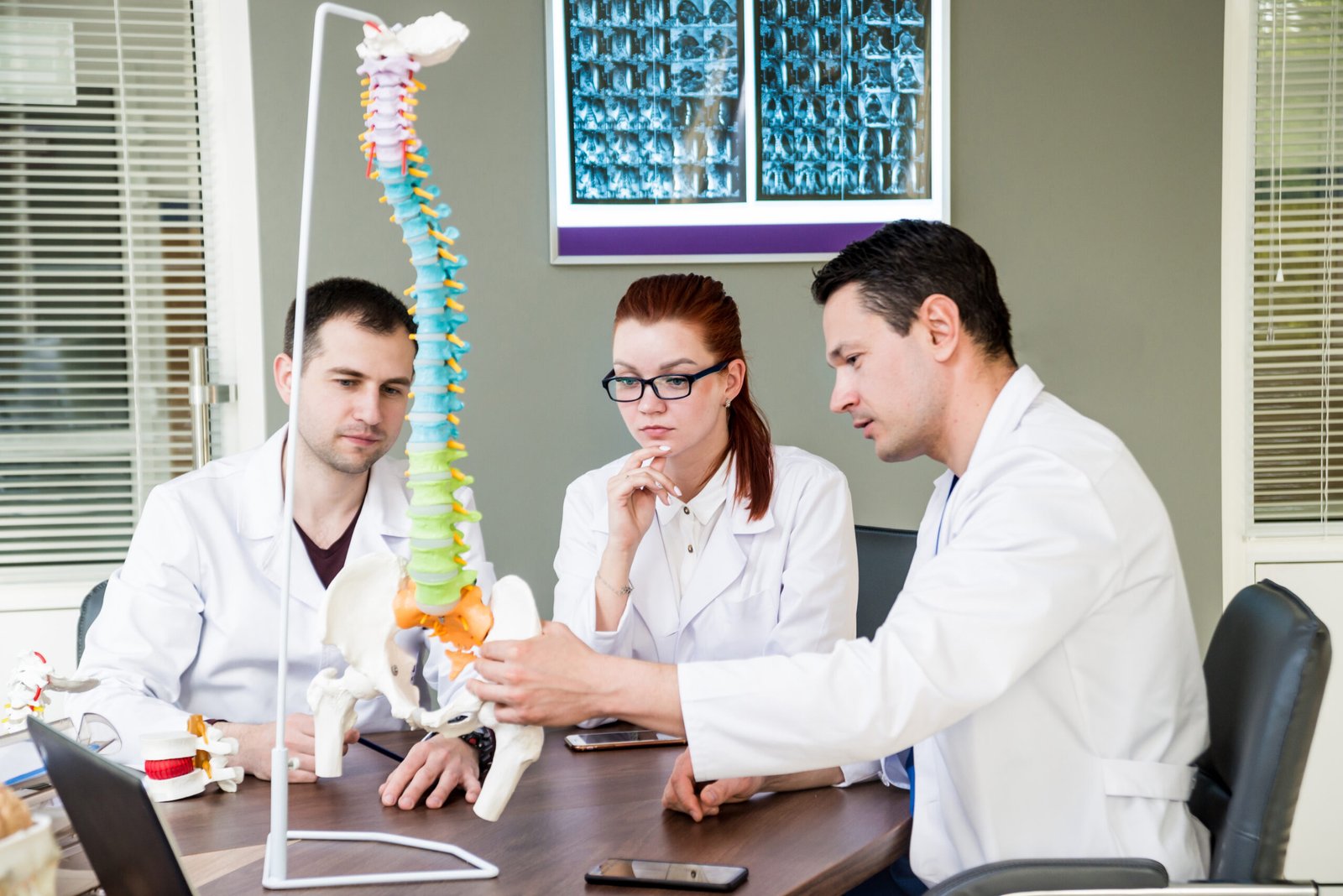 Doctors team having medical council in hospital. Discussing medical issues. Spine fixation systems. Spinal surgery