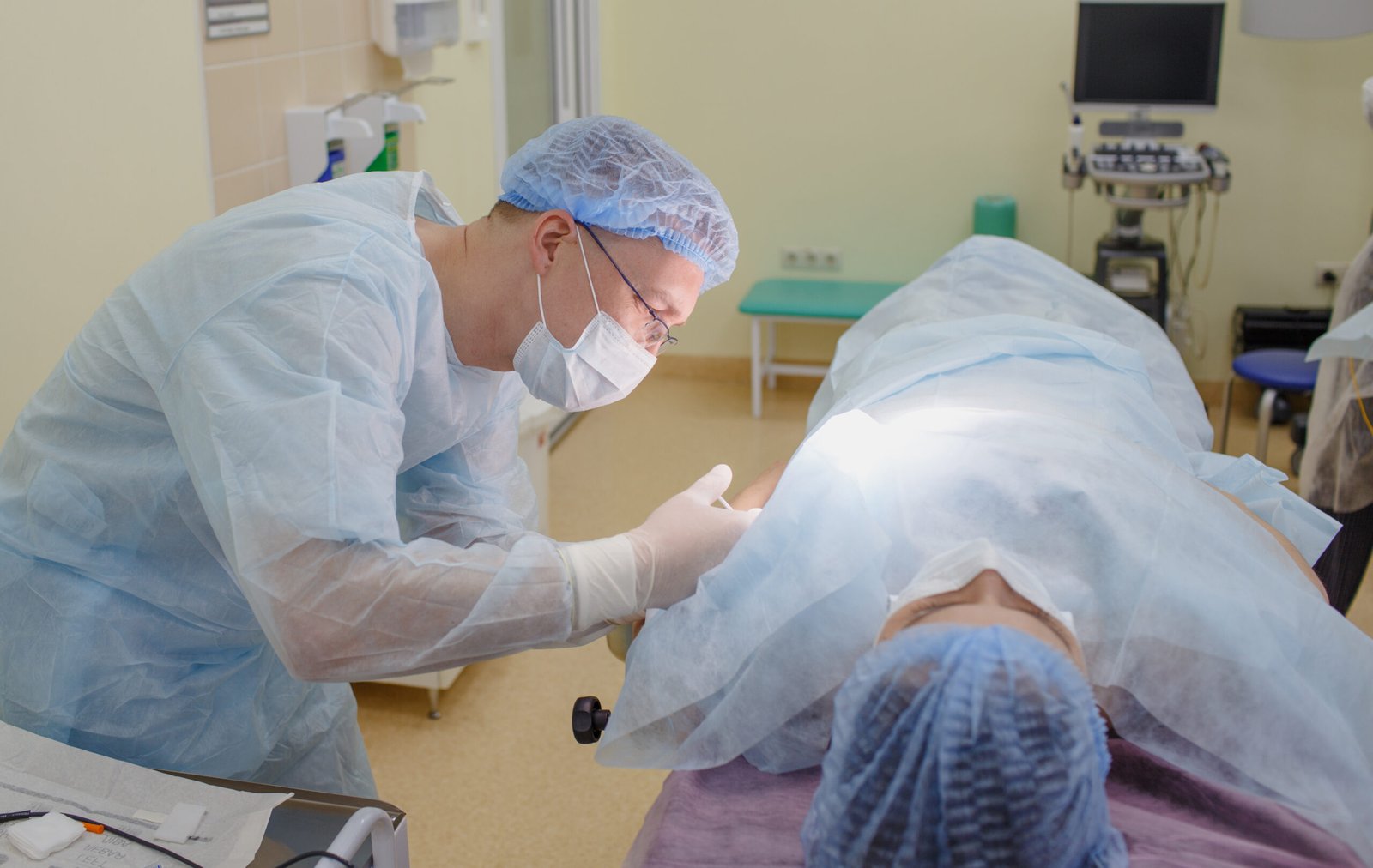 the surgeon injects the medicine to the patient lying on the operating table